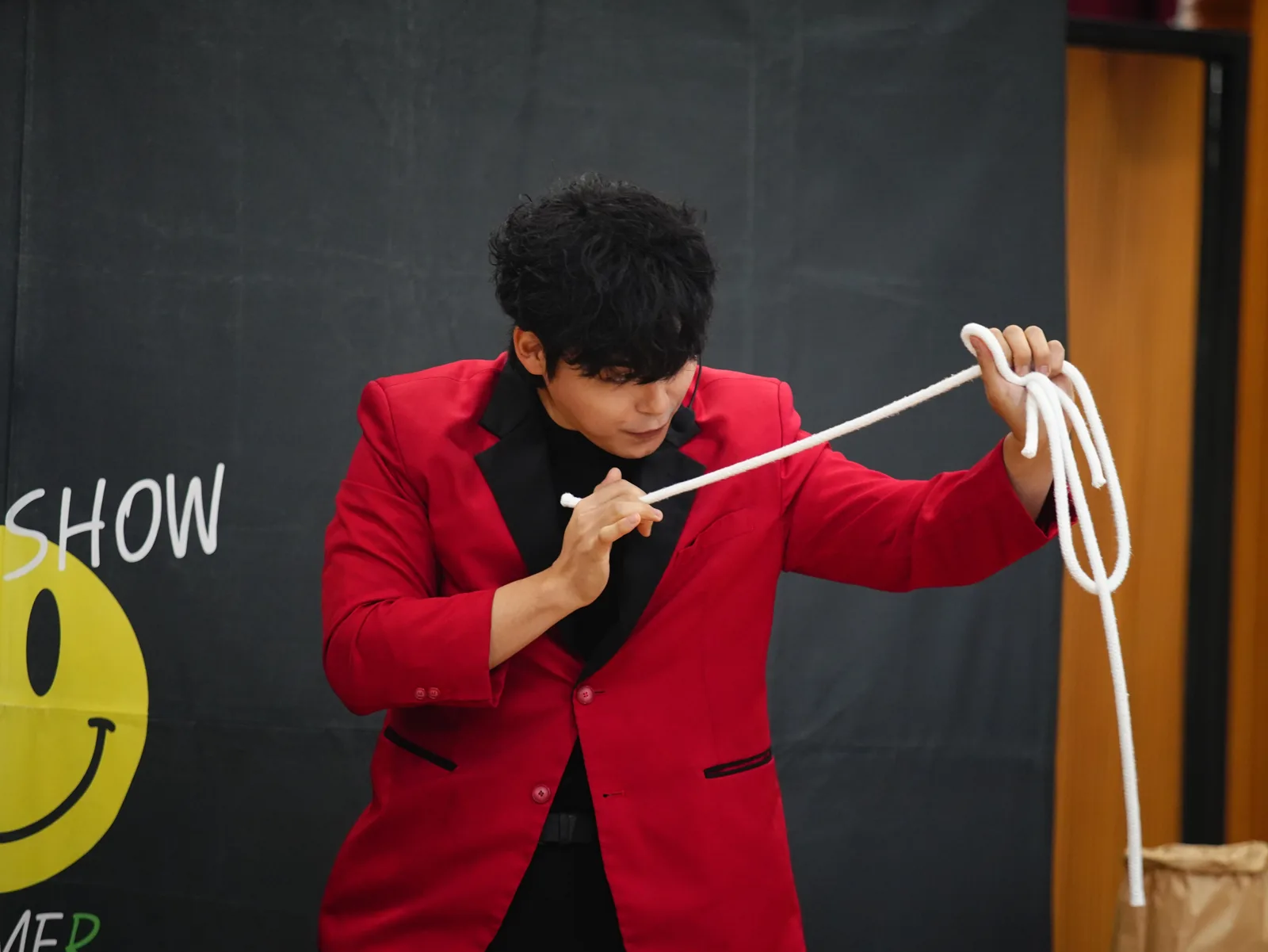빨간 재킷을 입고 로프 마술을 하는 하지완